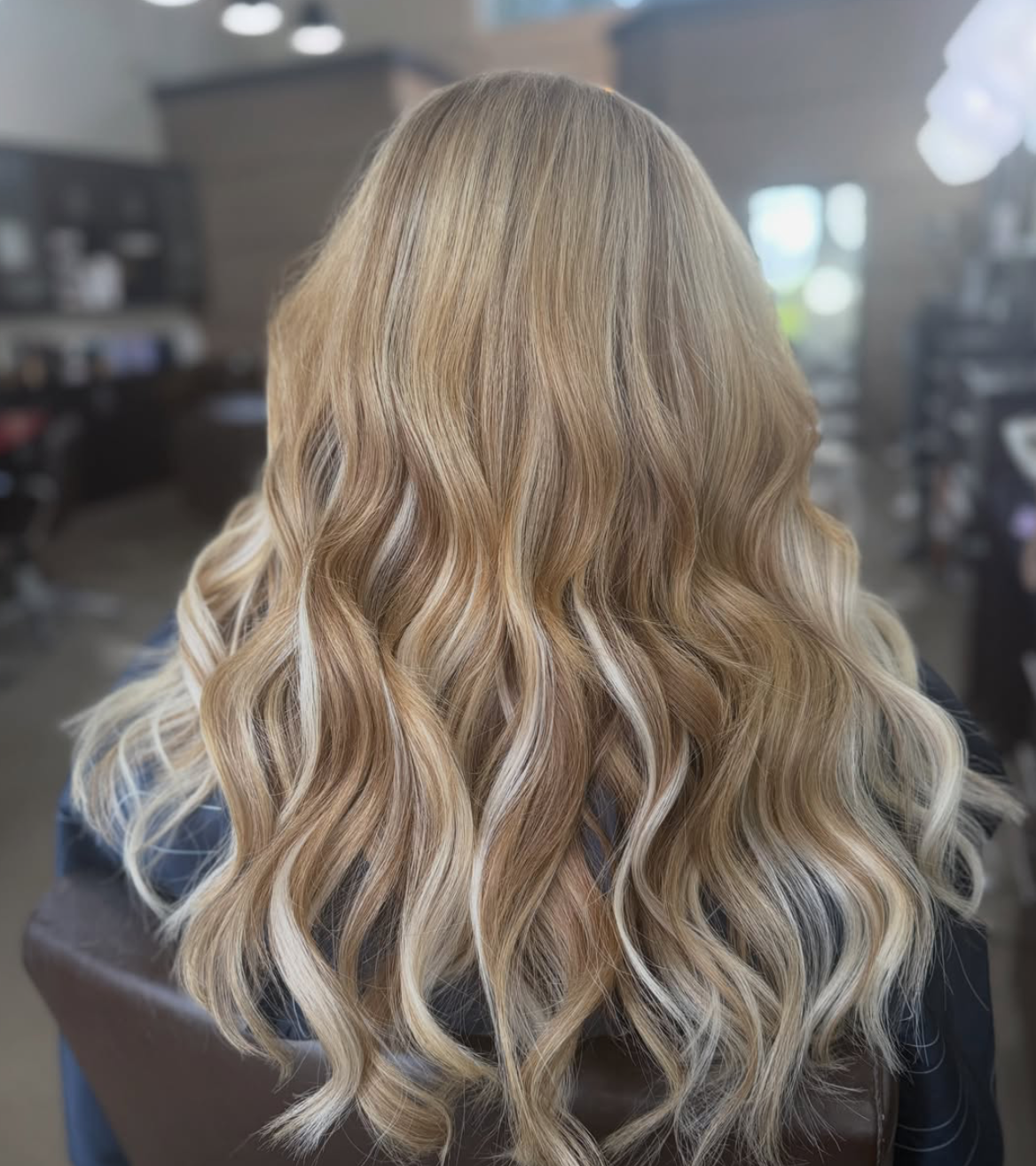Soft blonde balayage with bright face-framing highlights and loose waves